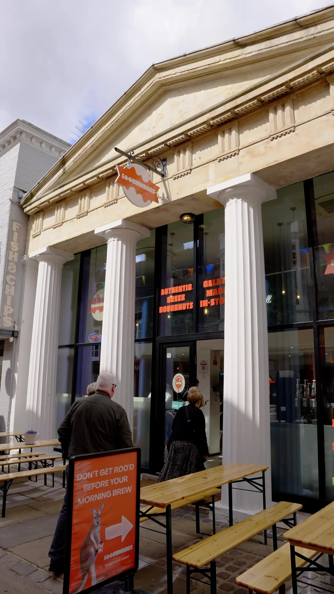 Lookumades Canterbury’s columned stone frontage, orange shop sign and outdoor seating on St Margaret’s Street
