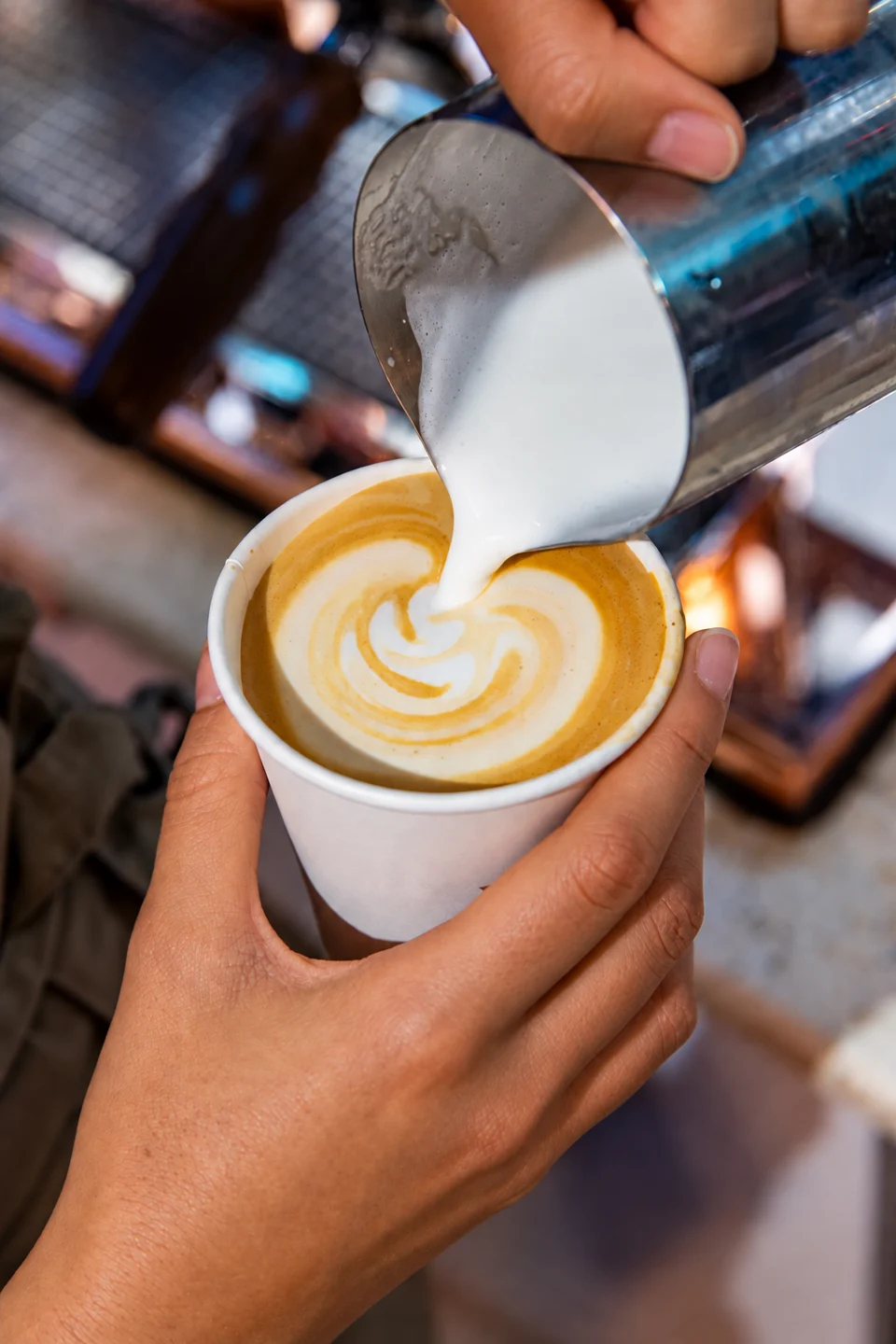 Close-up of steamed milk being poured into coffee at Lookumades