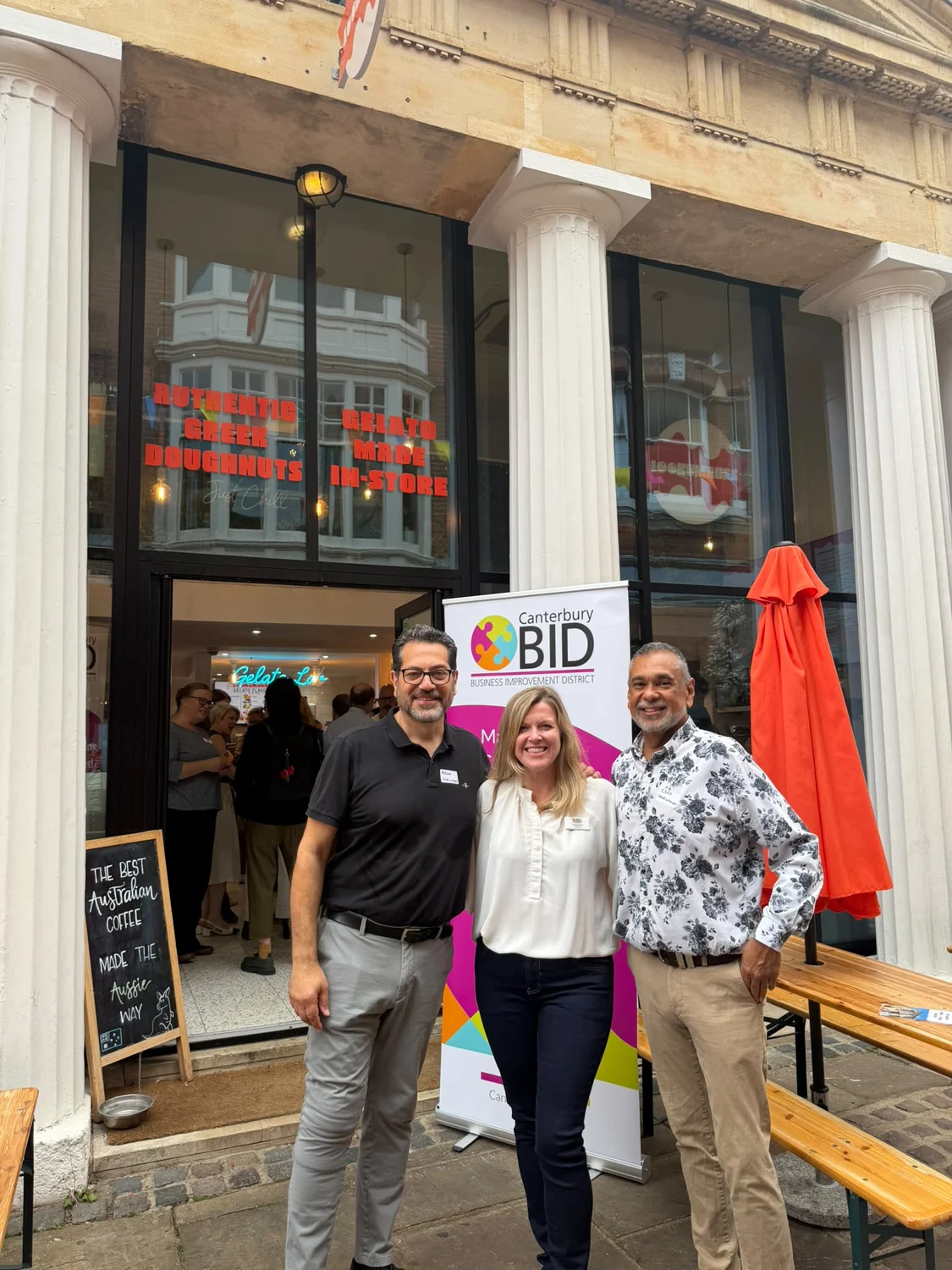Adam and Cliff with a guest outside Lookumades beside the Canterbury BID banner