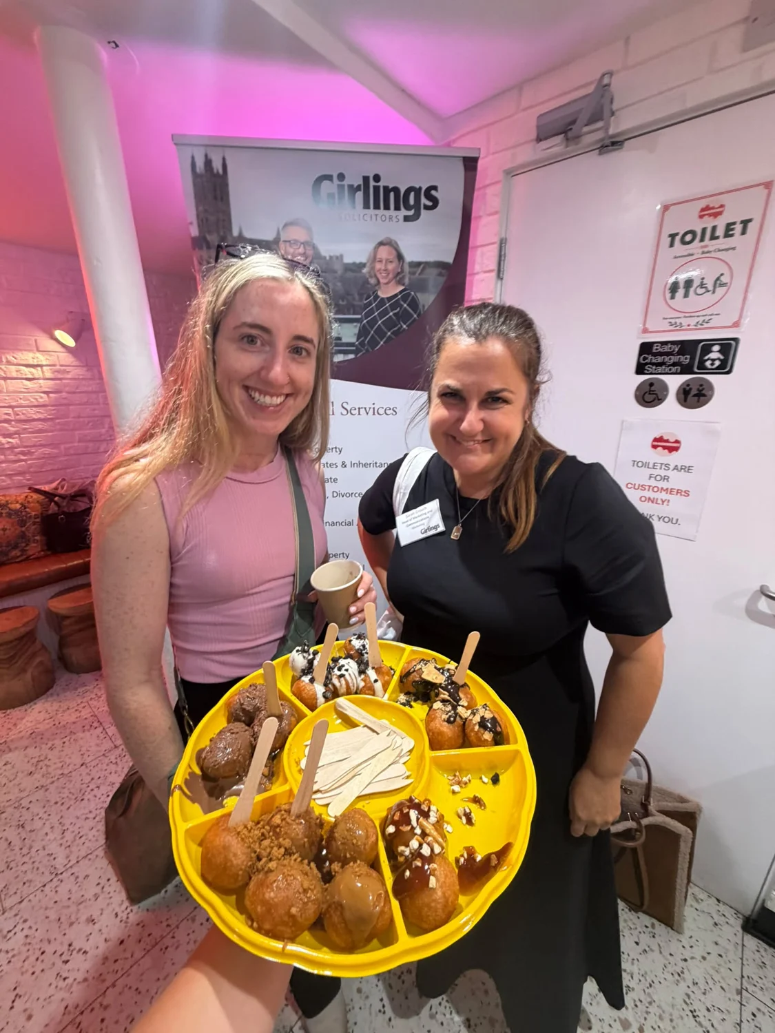 A Lookumades team member and guest smiling with a tray of Loukoumades